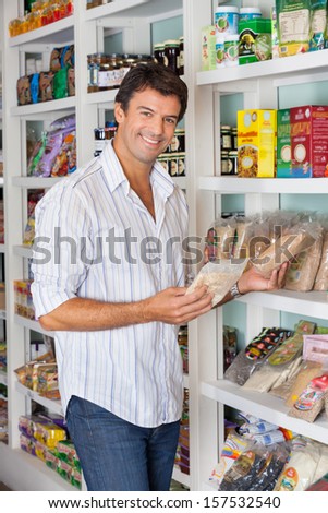 Portrait of happy mid adult man shopping in grocery store