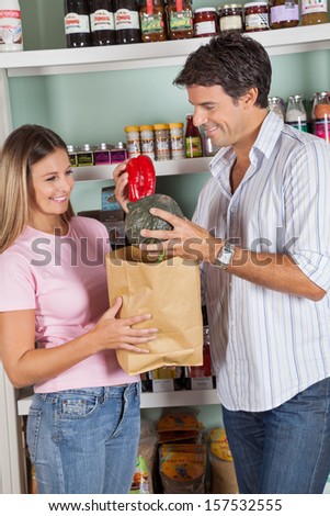 Happy mid adult couple shopping vegetables in supermarket