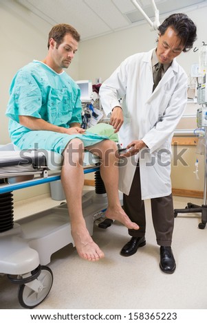Doctor testing reflexes on emergency patient