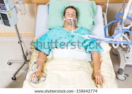High Angle View Of Critical Patient With Endotracheal Tube Resting On Bed In Hospital