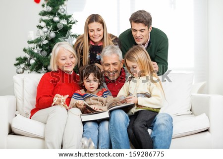 Happy Multigeneration Family Reading Book Together In House