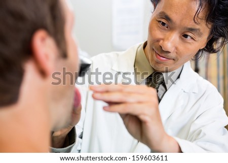 Male doctor examining patient\'s mouth in ER