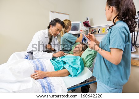 Team of doctor and nurses examining patient in hospital