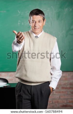 Portrait of confident male professor gesturing in classroom