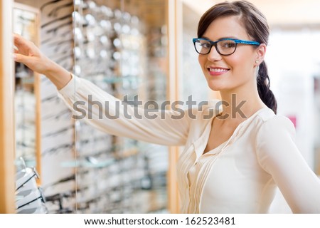 Portrait Of Happy Young Woman Buying New Glasses At Optician Store