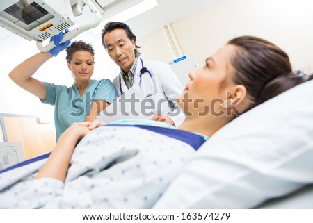 Doctor and nurse preparing young patient for xray in examination room.  Shallow DOF focus on staff