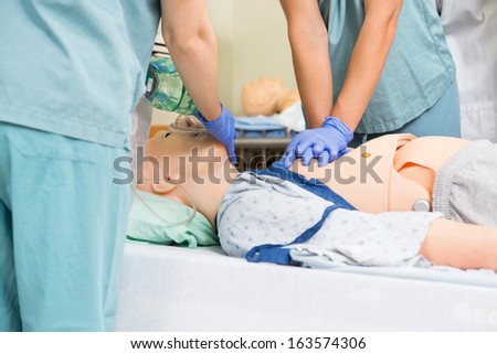 Midsection of nurse performing CRP on dummy patient in hospital room Midsection of nurse performing CRP on dummy patient in hospital room