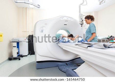 Mid Adult Nurse Preparing Patient For Ct Scan Test In Hospital Room