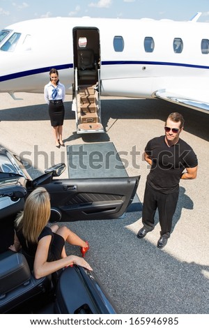 Woman Stepping Out Of Car Parked By Bodyguard; Airhostess And Private Jet