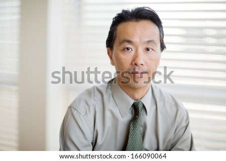 Portrait of confident male cancer specialist in shirt and tie at clinic