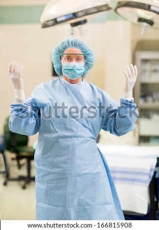 Portrait of female doctor in surgical gown standing in operation room