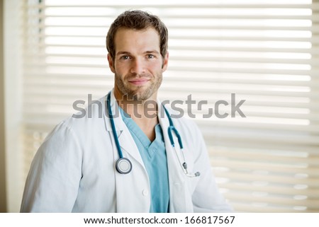 Portrait of handsome male cancer specialist with stethoscope around neck at clinic