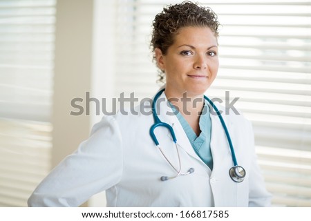 Portrait of confident female cancer specialist in labcoat smiling at clinic