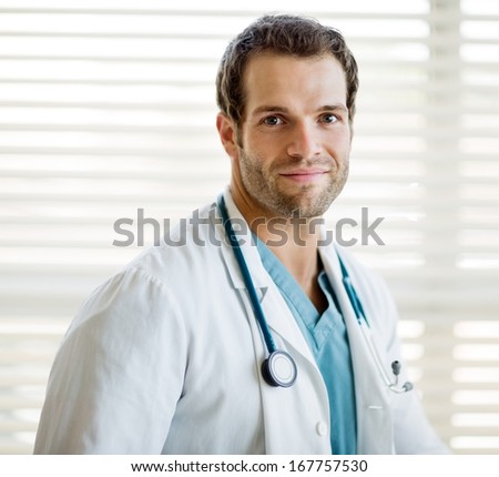 Portrait of confident male cancer specialist with stethoscope around neck at clinic