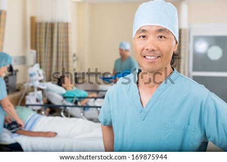 Portrait of smiling male nurse standing in hospital ward