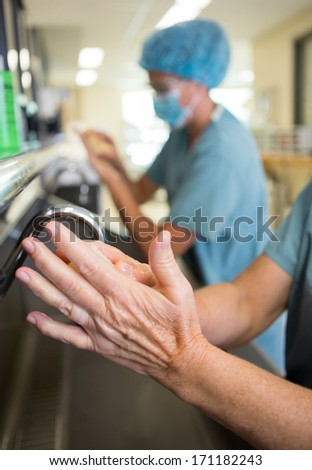 Detail of surgeon doing a surgical scrub on hands and arms