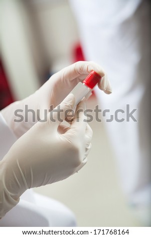 Cropped image of female technician labeling test tube in lab