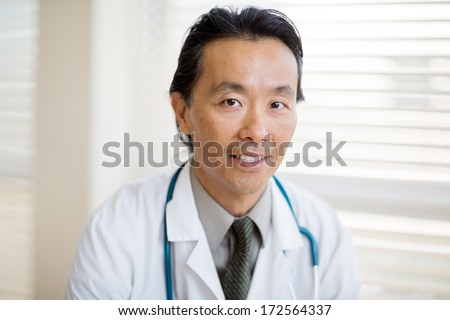 Portrait of Asian male cancer specialist with smiling in hospital