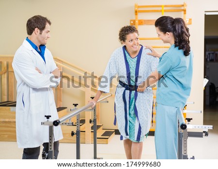 Female Patient Being Assisted By Physical Therapists In Hospital