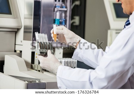 Midsection of male scientist analyzing urine samples in laboratory Midsection of male scientist analyzing urine samples in laboratory