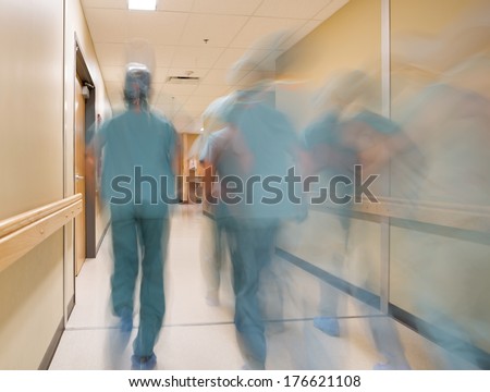 Blurred motion doctors and nurses walking in hospital corridor Blurred motion doctors and nurses walking in hospital corridor