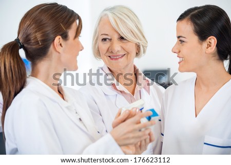 Happy female researchers discussing over medicine in hospital