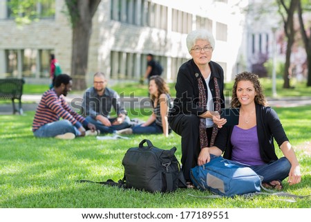 Portrait of confident female student with digital tablet receiving help from professor