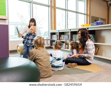 Teachers and elementary students in school library