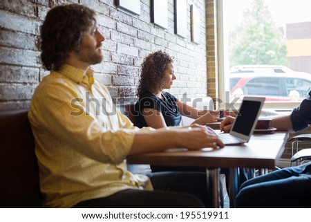 Male and female customers spending leisure time in coffeeshop