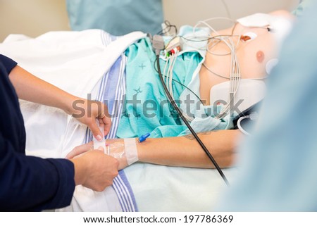 Nurse attaching IV solution on critical male patient\'s hand in hospital