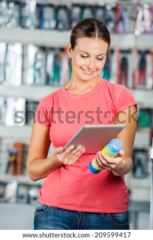 Beautiful mid adult woman scanning product\'s barcode through digital tablet in hardware store