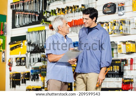 Happy father with son checking list in hardware store