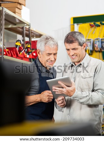 Salesperson and customer using digital tablet in hardware store