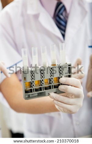 Cropped image of researcher holding testtube rack in laboratory