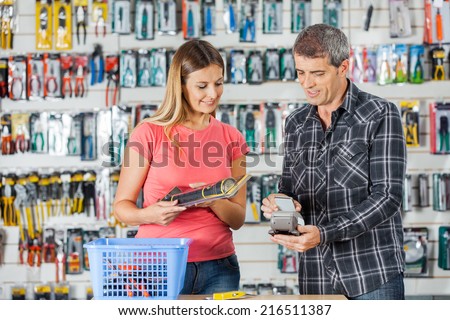 Man and woman making electronic payment in hardware store
