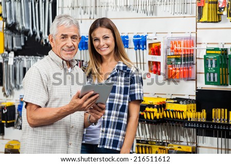 Portrait of happy woman and father with digital tablet in hardware store