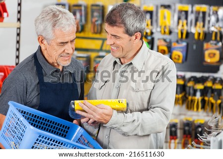 Senior salesman assisting customer in buying product at hardware store
