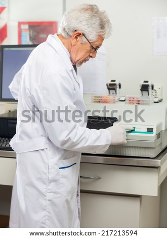 stock-photo-side-view-of-mature-male-scientist-analyzing-samples-using-analyzer-in-lab-217213594.jpg