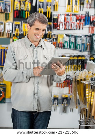 Mature male customer man using tablet computer in hardware store