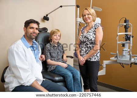 Portrait of mid adult optician with customers smiling in store