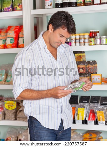 Mid adult man choosing product in grocery store