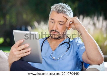 Male doctor using tablet PC in nursing home