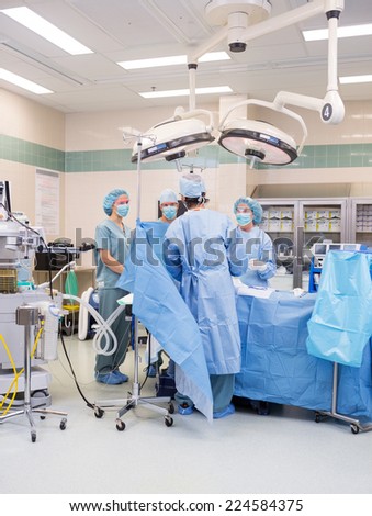 Surgeons operating on patient in surgical theater in hospital