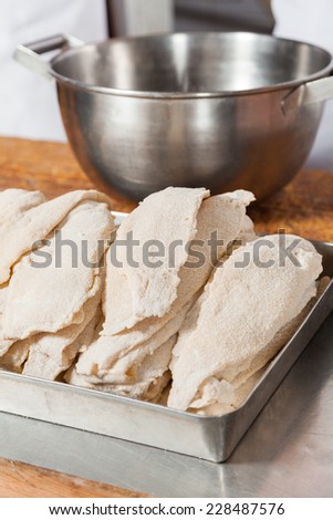 Stack of chicken pieces arranged in tray at butcher\'s shop