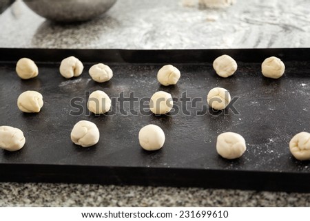 Pasta dough balls in tray on countertop in commercial kitchen