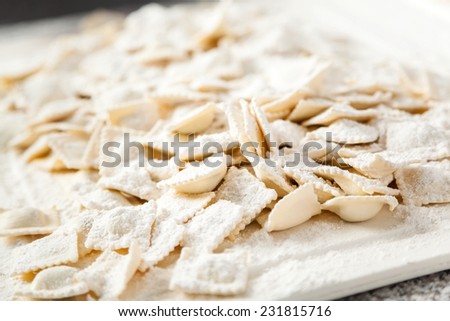 Closeup of flour on raw ravioli pasta at counter in commercial kitchen