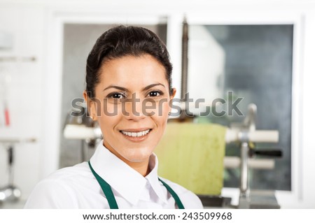 Portrait of happy young female chef at commercial kitchen