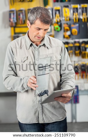 Mature male customer scanning product through digital tablet in hardware store