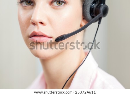 Closeup portrait of female customer service representative wearing headset in office
