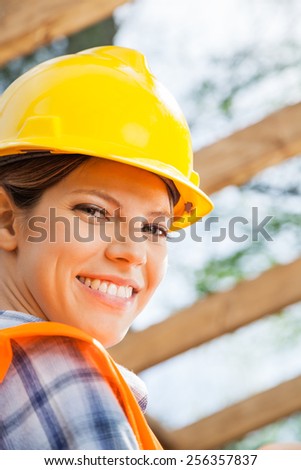 Closeup portrait of happy female construction worker at site